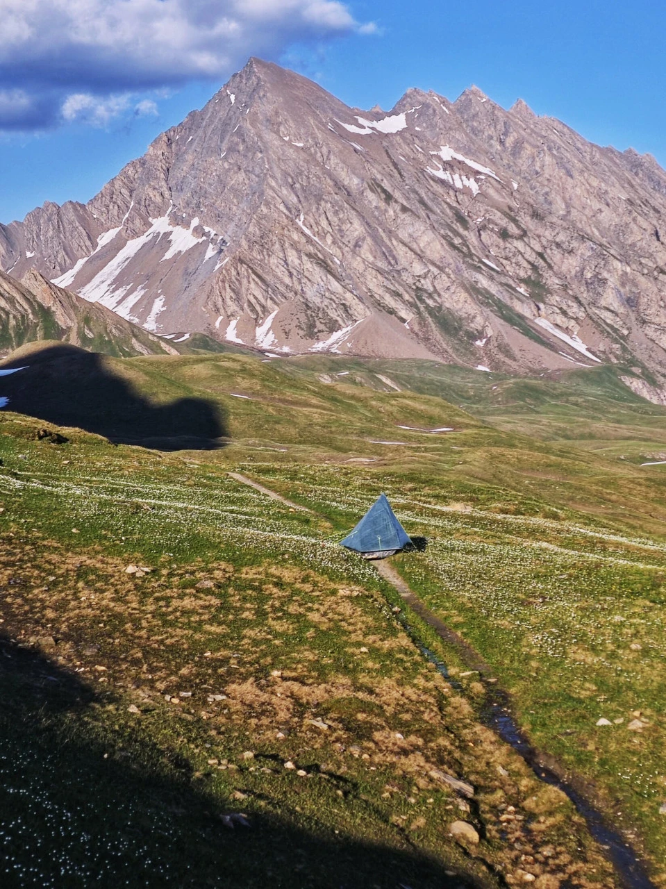 Zelt auf einer Alm des TMB Anfang Juni, winzig unter dem Gipfel und dem noch vorhandenen Schnee: eine Stimmung, die es so nicht mehr gibt, sobald die Hochsaison läuft