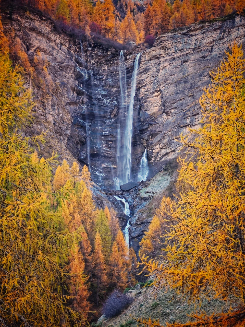 Der Wasserfall Cascade de la Pisse bei Champoléon, zwischen herbstlichen Lärchen